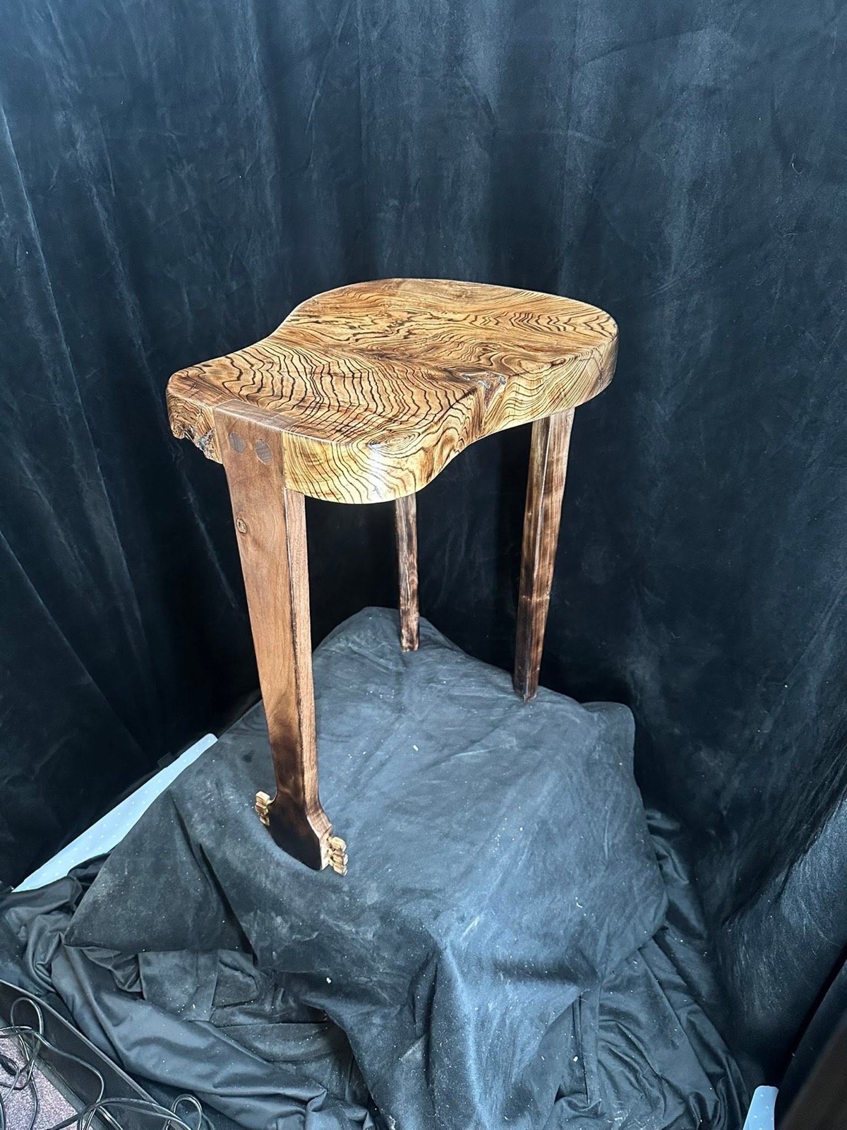 A handcrafted side table with striking twisted wood grain, handmade by Twisted Grains Woodworking